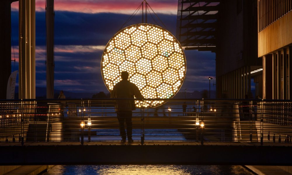 a sun on the horizon in the oslo fjord made with hundreds of light bulbs with a slow animation